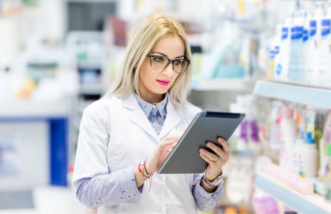 Farmaceutka z tabletem w dłoni w aptece