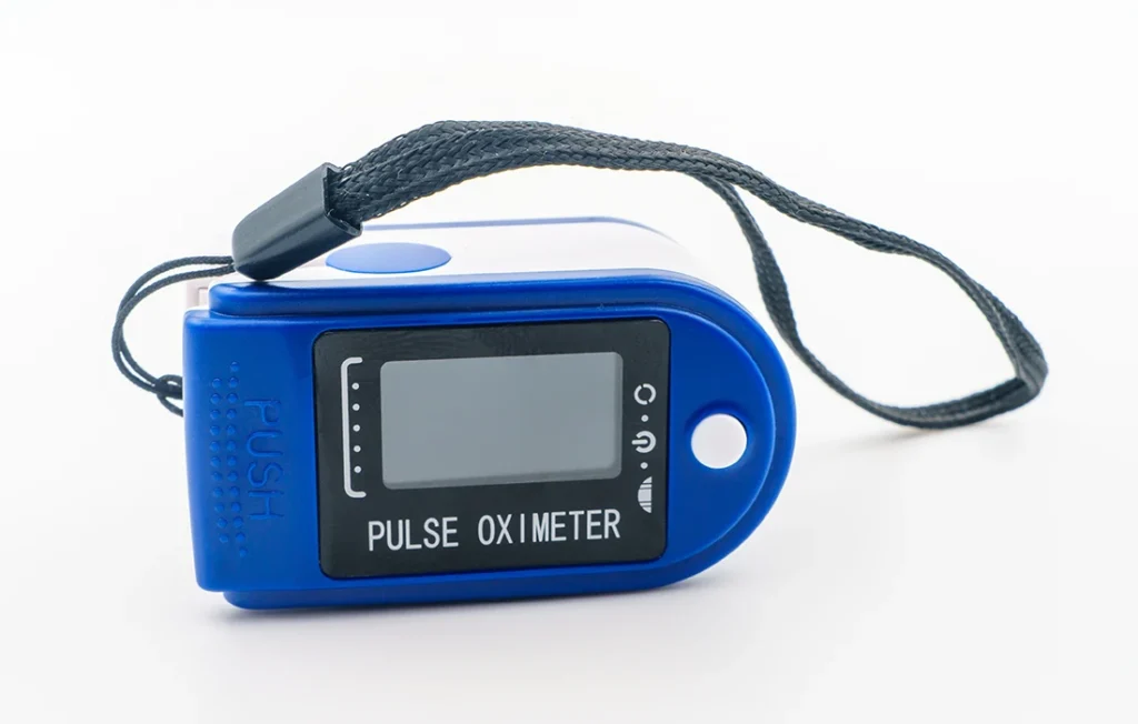 Niebiesko-biały pulsoksymetr z czarnym paskiem na nadgarstek, przedstawiony na białym tle.